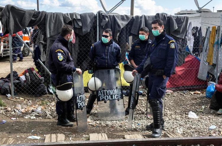 grænsevagt. Politifolk holder vagt for at forhindre uro ved flygtningelejren i Idomeni. Politimanden George er ikke med på billedet. 