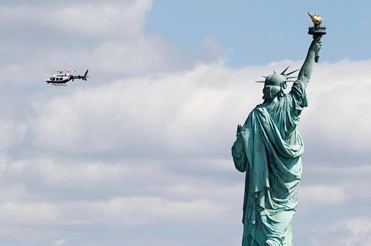 SIGHTSEEING. Helikopterturene over New York koster fra 1.000 kroner og opefter. Her er det en politihelikopter, som runder Frihedsgudinden. Foto: Julio Cortez/AP 