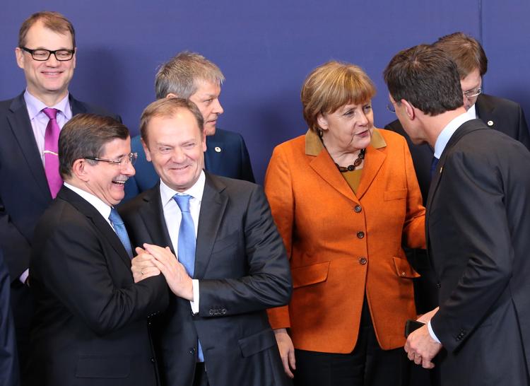 Aftale. Efter at have forhandlet det meste af dagen er EU-landenes ledere nået frem til en aftale med Tyrkiet om at bremse flygtningestrømmen. Her ses Tyrkiets regeringsleder, Davutoglu (t.v.), der trykker hånd med EU-præsident Donald Tusk. 