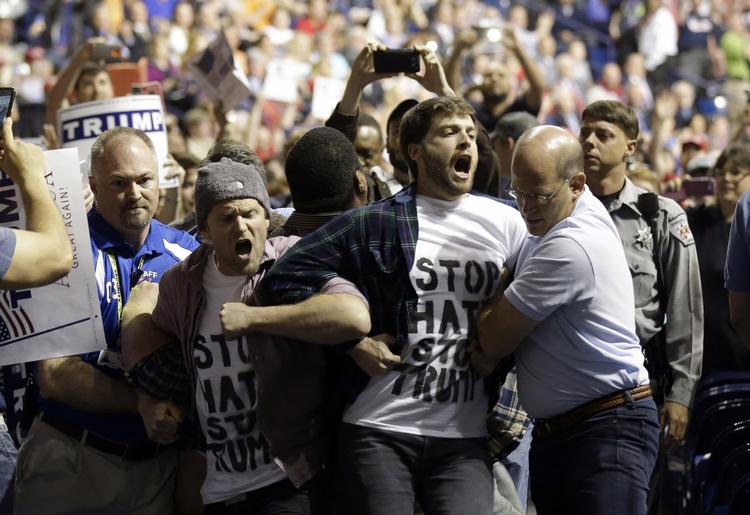 Uenighed. Her bliver nogle af demonstranterne modvilligt fjernet fra Donald Trumps valgmøde i Fayetteville, North Carolina. 