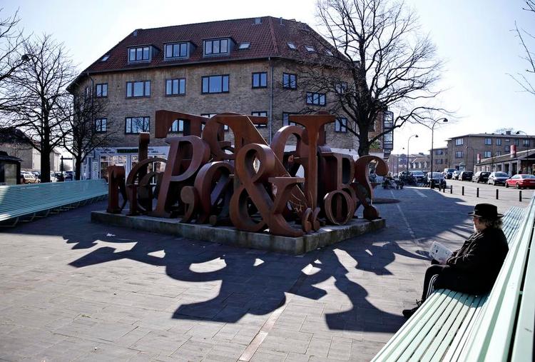 vangede. Bænken rundt om Dan Turèlls Plads i Vangede er 47 meter lang. En meter for hvert år, digteren levede. Dan Turéll ville være blevet 70 år, hvis han ikke var død i 1993. Skulpturen er skabt af Kenn André Stilling. Han er sikkert med til en af de mange fester for Onkel Danny på lørdag. Foto: 