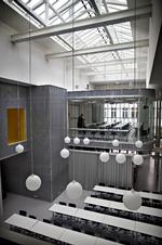 Svævende. Møderummet, der skyder sig ud af den store aluminiumsklædte installation, står som ombygningens centrale motiv. Til venstre ser man den gule gang, der fører til kantinen. Møbleringen, som brugerne selv står for, har desværre ikke helt niveau med ånden i ombygningen. 