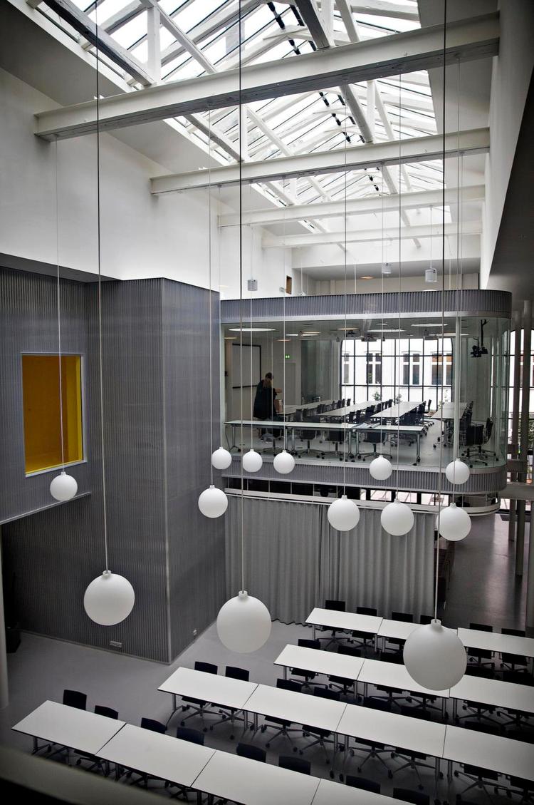 Svævende. Møderummet, der skyder sig ud af den store aluminiumsklædte installation, står som ombygningens centrale motiv. Til venstre ser man den gule gang, der fører til kantinen. Møbleringen, som brugerne selv står for, har desværre ikke helt niveau med ånden i ombygningen. 