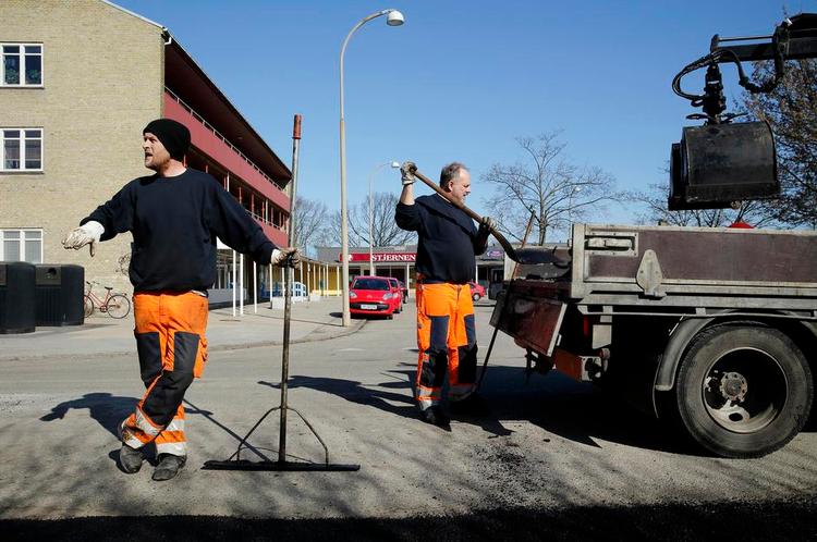 Arbejdsglæde. Ronnie Larsson (tv) og John Kristiansen er glad for arbejdet med at lappe de kommunale veje i Gladsaxe. De vil gerne være med til at hjælpe flygtninge i job, men det må bare ikke stjæle jobbet fra danskere, siger de. 