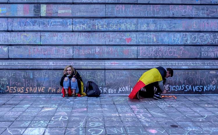 sorg. Uden for Børsen i Bruxelles strømmer fortsat folk til for at bearbejde deres chok og sorg. De tænder lys eller skriver slogans og mindes de dræbte. Vi glemmer hverken jer eller det, der skete. Foto: Mads Nissen 