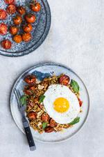 ÆGGETOPPING. Søde bagte tomater, lidt stærk harissa og knasende mandelflager er et fint modspil til et spejlæg. 