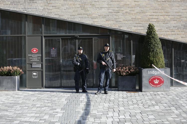 bevogtet. Betjente med automatvåben bevogter Retten på Frederiksberg, hvor tilskuerne bliver undersøgt med metaldetektorer, inden de fik lov at komme ind. 