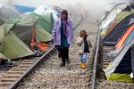 Flugt. Flygtninge går tidligt om morgenen mellem teltene i en flygtningelejr ved den græske landsby Idomeni ved grænsen til Makedonien. 