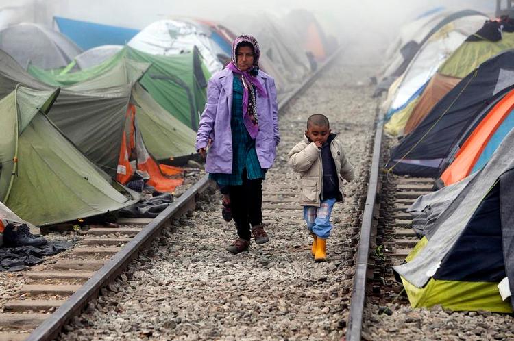 Flugt. Flygtninge går tidligt om morgenen mellem teltene i en flygtningelejr ved den græske landsby Idomeni ved grænsen til Makedonien. 