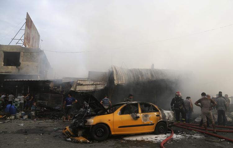 brand. Irakiske brandmænd forsøger at slukke ilden, som selvmordsbomben udløste. 