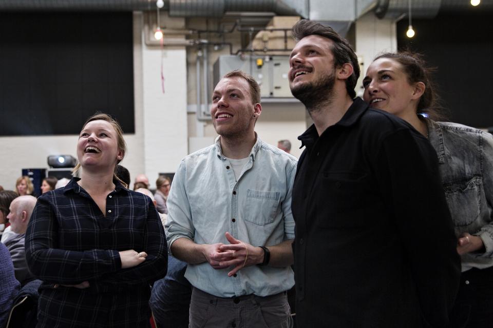 Gruppebillede. Ninna Jurs (tv), Daniel Evensen, Laurids Bæk Simonsen og Wiebke Averbeck er blevet fotograferet og billedet kører på storskærm sammen med andre billeder af gæsterne. 