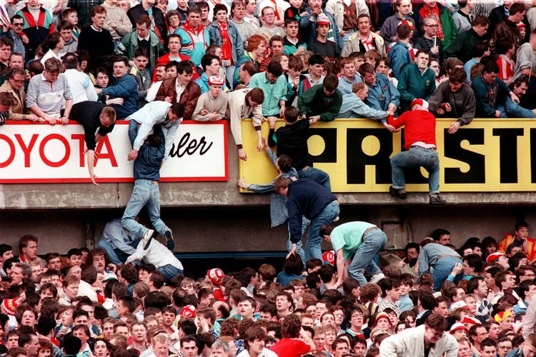 KLEMT. Desperate foldboldtilskuere forsøger at komme væk fra en af de overfyldte tribuner under kampen i 1989. 