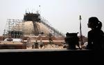 Genopbygning. En nepalesisk kvinde betragter genopførelsen af  Boudhanath Stupa, der blev beskadiget i sidste års jordskælv. Landets premierminister har netop meddelt, at man påbegynder genopbygningen af en række ødelagte kulturarvssteder i Kathmandu. Foto: Niranjan Shrestha/AP 
