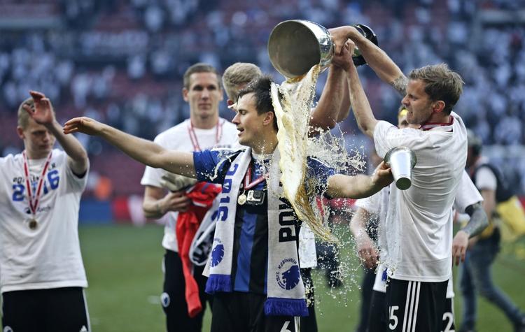 kæbebrud. Mikael Antonsson (th) var frisk nok til at fejre pokalsejren mod AGF og hælde lidt øl ud over FCK's matchvinder William Kvist. Men svenskeren fik sig et kæbebrud i kampen, hvilket holder ham ude af EM. 