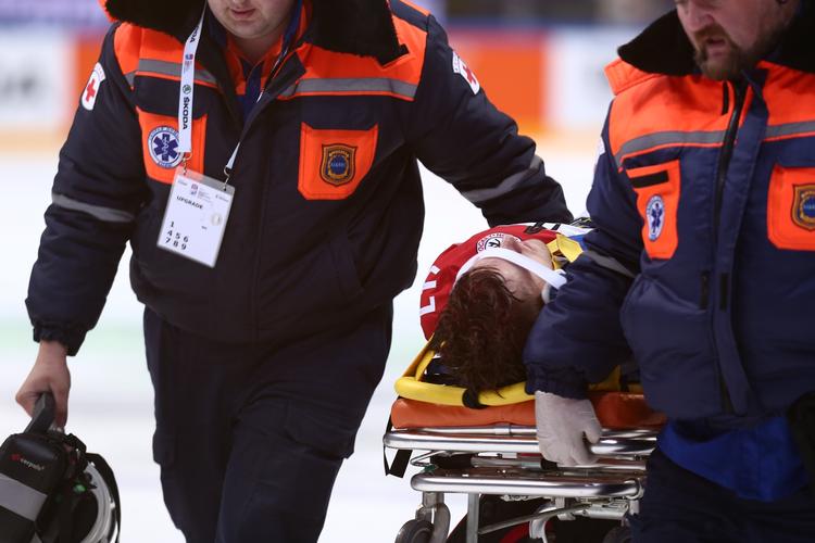 færdig. Jesper B. Jensen hjælpes fra banen på en båre efter den høje og hårde tackling, der efterlod ham liggende på isen i flere minutter i kampen mod Schweiz. 