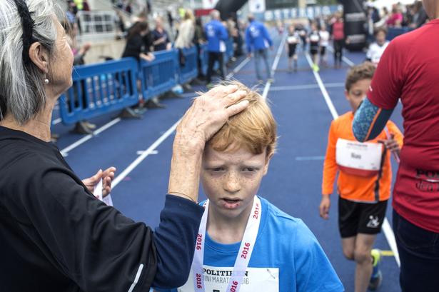 HÅNDSPÅLÆGGELSE. Medaljeoverrækkeren hygger lidt om en af drengene. 