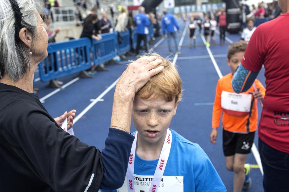 HÅNDSPÅLÆGGELSE. Medaljeoverrækkeren hygger lidt om en af drengene. 