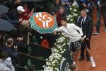 TAK. Novak Djokovic lånte tirsdag en paraply hos en venlig tilskuer på Roland Garros-anlægget i Paris, der stadig mangler et skydetag over hovedbanen. 