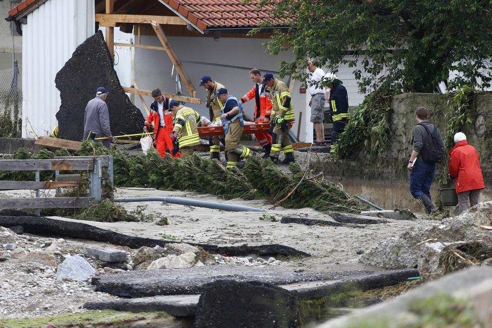 Redningsfolk bærer en kvinde i sikkerhed. 