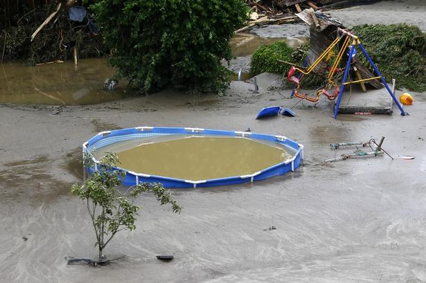 En swimmingpool står tilbage i vandmasserne.... 