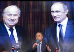 Belastet. Vitalij Mutko - den russiske sportsminister, der har taler mellem billeder af skandaliserede Sepp Blatter og præsident Putin - er en af de mest udskældte ledere i Uefa og Fifa, da han både er mistænkt for korruption og at styre et dopingregime. Arkivfoto: Alexander Zemlianichenko/AP 