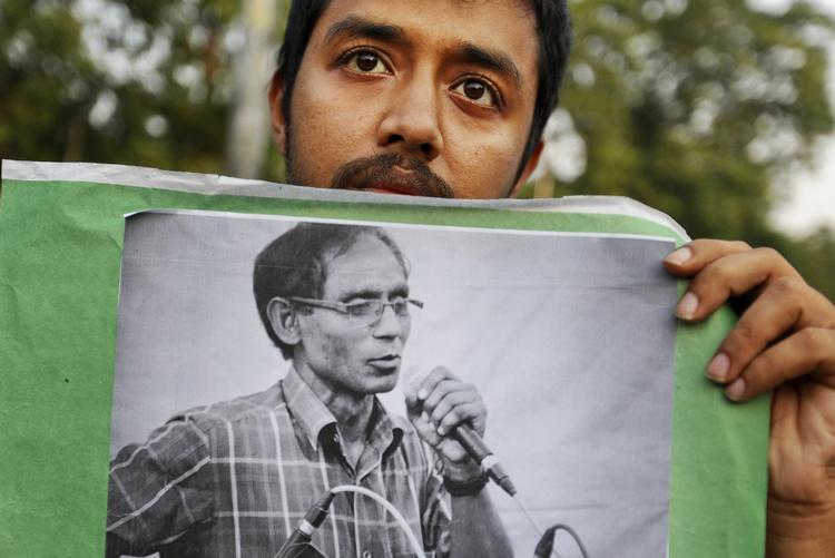 DRAB. En studerende holder et foto frem af en professor, der er blevet dræbt i Bangladesh. 