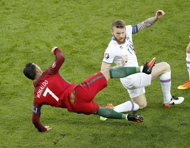 KAPTAJN. Aron Gunnarsson i sammenstød med Portugals store stjerne Cristiano Ronaldo, der blev noget frustreret over den manglende succes over for modstandernes kontante defensiv. 