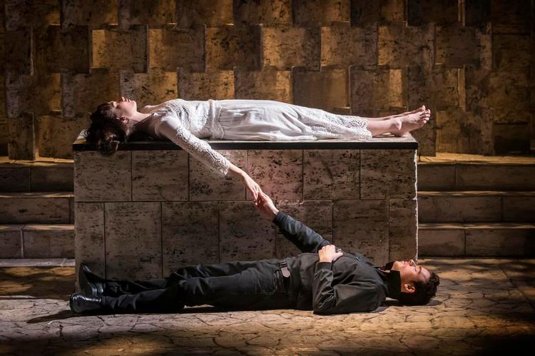 Splittelse. Romea og Julie ligger hver for sig, men dog forenede i døden (Lily James og Richard Madden) - i Kenneth Branaghs opsætning.