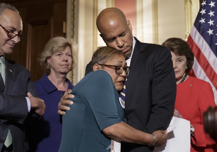 Støtte. Under et pressemøde forleden fik en af de demokratiske senatorer, Cory Booker fra New Jersey, et kæmpeknus af Sharon Risher. Hun mistede sin mor og to andre familiemedlemmer for godt et år siden under et skyderi i en kirke i Charleston, South Carolina. 