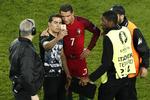 overskud. Sikkerhedsfolk stod på spring for at fjerne en baneløber, men Cristiano Ronaldo gav efter en skidt kamp plads til et foto sammen med tilhængeren, inden han blev ført væk. 