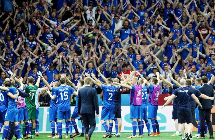 Tak. De islandske fodboldspillere sejrer den overraskende 2-1-sejr over England ved EM sammen med deres fans. Foto: Claude Paris/AP 