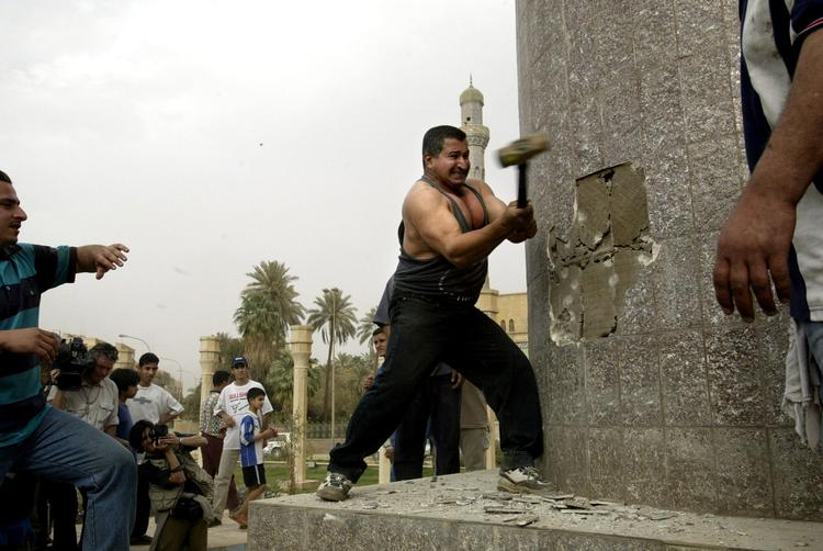 Duns. Mekanikeren Kadhim al-Jabouri hamrer løs på basen af enorm statue af Saddam Hussein, Iraks præsident, i Bagdads centrum 9. april 2003. Kort forinden havde allierede styrker indtaget byen og detroniseret diktatoren. 