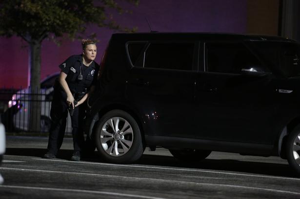 ANGREB. Betjent søger ly under ildkampene i den amerikanske storby. 