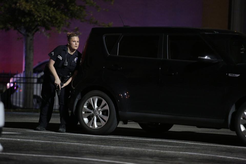 ANGREB. Betjent søger ly under ildkampene i den amerikanske storby. 