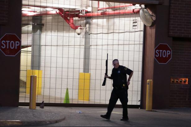 En betjent går forbi en lukket garage. 