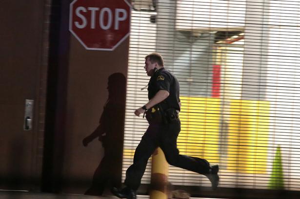 En betjent løber i dækning i en garage. 