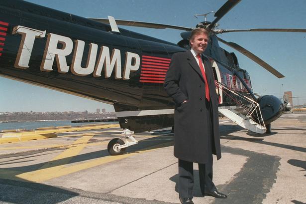 Donald Trump og en af hans tre helikoptere i marts 1988. Trump har en forkærlighed for at sætte sit eget navn på sine ejendele såvel som forretninger. 