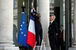 sørgebånd. En ansat ved Elysee præsident-paladset sætter sørgebånd på flagene, efter at Frankrigs præsident har deklareret tre dages landesorg. 