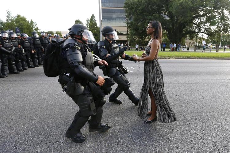 Anholdelse. Billedet er taget i Baton Rouge i staten Lousiana i USA under en demonstration mod politiet i lørdags. Kvinden her ville ikke flytte sig, men stod ubevægelig på vejen, mens de to betjente kom mod hende. 