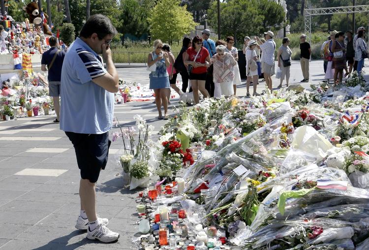 Sorg. En mand betragter de mange blomster, der er placeret ved et mindesmærke på strandpromenaden i Nice, hvor et stort antal uskyldige blev dræbt. 