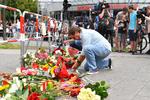 Sorg. En mand lægger blomster foran mindested for de dræbte ved fredagens skudattentat. 