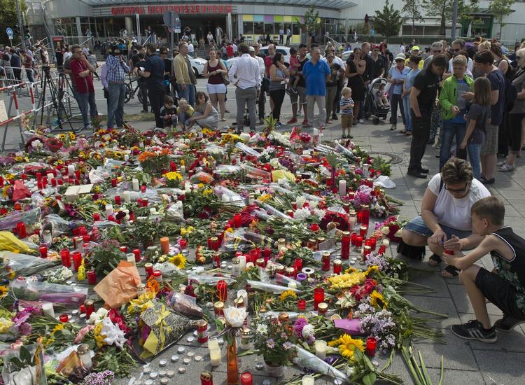 Massedrab. Blomsterhav foran det indkøbscenter i München, hvor ni personer fredag blev dræbt af en gerningsmand, der senere skøde seig selv. 
