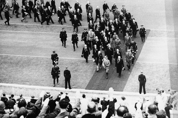Ankomst. Tilskuerne hylder Hitler ved sin ankomsten til stadion. Kort efter indtog han selv podiet og talte til de fremmødte. 