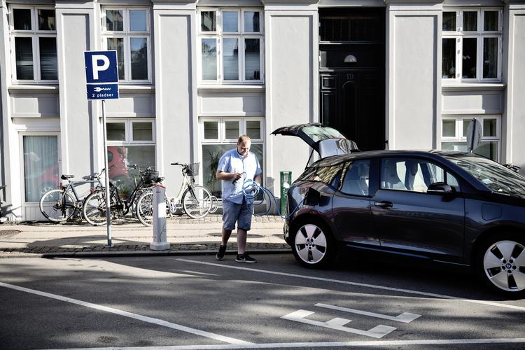 LADEKLAR. Søren Jæger Hansen pakker ladekablet sammen. I fremtiden bliver det muligvis forbudt at lade bilen, en BMW i3 REX til 367.000 kroner, op her. 