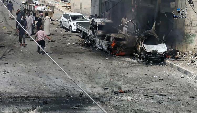 Foto fra Manbij fra slutningen af juli, som støtter af Islamisk Stat har delt. Viser, hvordan beboere fra byen samler sig omkring de nedbrændte biler efter et luftangreb på byen. 