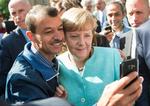 INDVANDRING. En mand får taget en selfie med forbundskansler Angela Merkel under et besøg på et asylcenter i Berlin. Nu vil hun have de store virksomheder til at ansætte flere flygtninge end de 54, det hidtil er blevet til. 