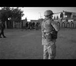 Overgreb. Foto fra video, der viser danske soldater i Irak, mens irakisk politi sparker fanger i baggrunden. 