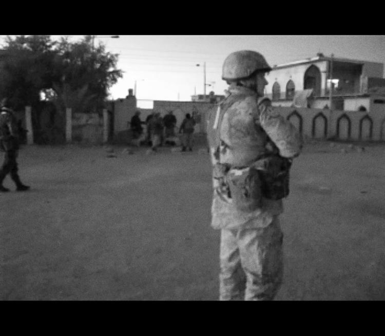 Overgreb. Foto fra video, der viser danske soldater i Irak, mens irakisk politi sparker fanger i baggrunden. 