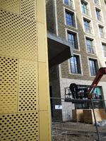 Flet. Materialerne på Carlsberg er tunge, men legende. Øverst tv. Praksis Arkitekters kommende forskerboliger med flettet murværk, nedenunder en gammel mur ved elefantporten med et mønster af udhævede sten og til højre mødet mellem forsker boligerne og en hullet guldfarvet alupassage, der måske er sjov, men helt uden forbindelse til stedets materielle kvalitet. 