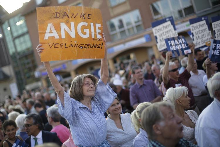 ANGELA Merkel har stadig fans, hvad denne kvinde viste på vælgermødet i Berlin, hvor kansleren dog også blev mødt af vrede tilråb. 